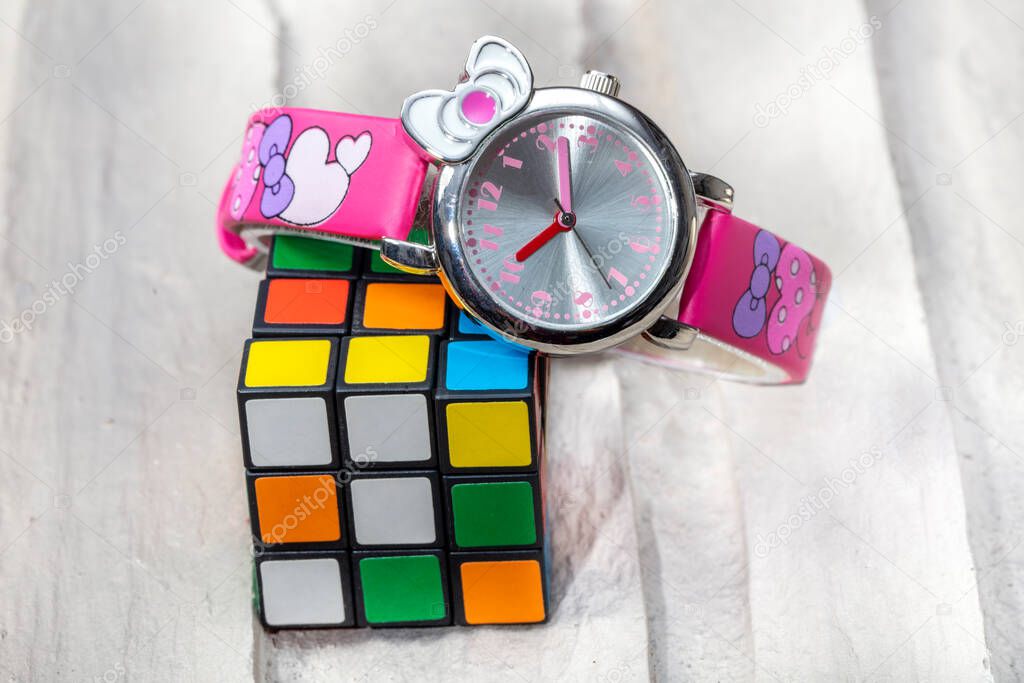 Intelligent cube and colorful children wristwatch on gray background.