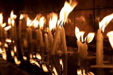 Tapınağı (kilise) ziyaret edin, kürsüdeki mumları yakmak için..