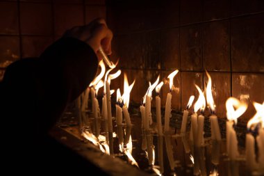 Tapınağı (kilise) ziyaret edin, kürsüdeki mumları yakmak için..