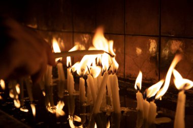 Tapınağı (kilise) ziyaret edin, kürsüdeki mumları yakmak için..