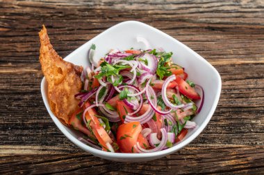 Tahta masadaki seramik tabakta mevsimlik sebze salatası.. 