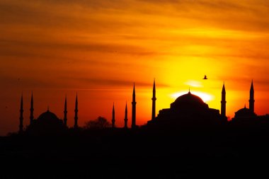 Mavi Cami ve Ayasofya üzerinde gün batımı. İstanbul 'da güneş batarken gökyüzü ve boğaz suları tutuştu 