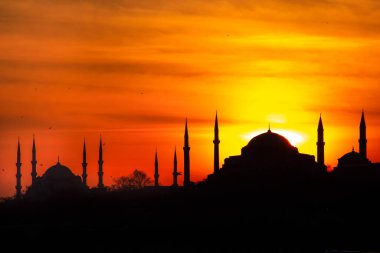 Mavi Cami ve Ayasofya üzerinde gün batımı. İstanbul 'da güneş batarken gökyüzü ve boğaz suları tutuştu 