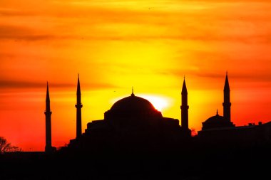 Mavi Cami ve Ayasofya üzerinde gün batımı. İstanbul 'da güneş batarken gökyüzü ve boğaz suları tutuştu 