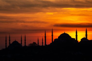 İstanbul Boğazı 'nda Ayasofya' nın siluetiyle Mavi Cami 'nin üzerinde güneş batıyor.