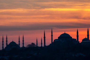 İstanbul Boğazı 'nda Ayasofya' nın siluetiyle Mavi Cami 'nin üzerinde güneş batıyor.