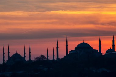 İstanbul Boğazı 'nda Ayasofya' nın siluetiyle Mavi Cami 'nin üzerinde güneş batıyor.
