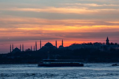 İstanbul Boğazı 'nda Ayasofya' nın siluetiyle Mavi Cami 'nin üzerinde güneş batıyor.