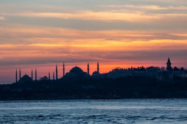 İstanbul Boğazı 'nda Ayasofya' nın siluetiyle Mavi Cami 'nin üzerinde güneş batıyor.