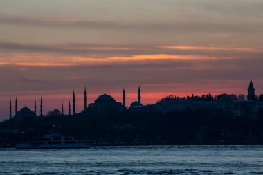İstanbul Boğazı 'nda Ayasofya' nın siluetiyle Mavi Cami 'nin üzerinde güneş batıyor.