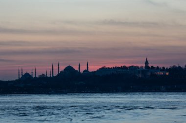 İstanbul Boğazı 'nda Ayasofya' nın siluetiyle Mavi Cami 'nin üzerinde güneş batıyor.