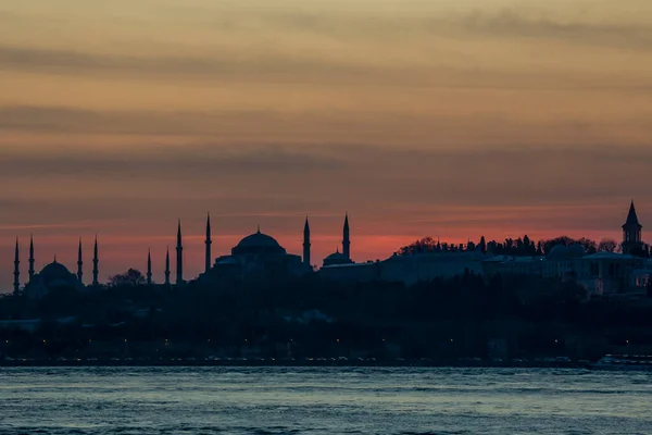 日落时分 与Hagia Sophia一起在伊斯坦布尔博斯普鲁斯海峡上的轮廓中俯瞰蓝色清真寺 — 图库照片