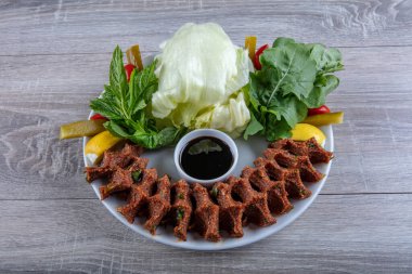 Porselen tabakta limonlu, marullu ve maydanozlu Türk Cig Kofte. 