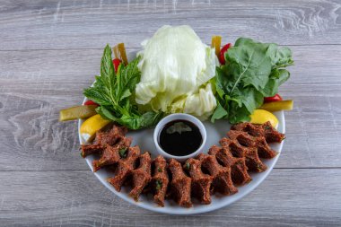 Porselen tabakta limonlu, marullu ve maydanozlu Türk Cig Kofte. 