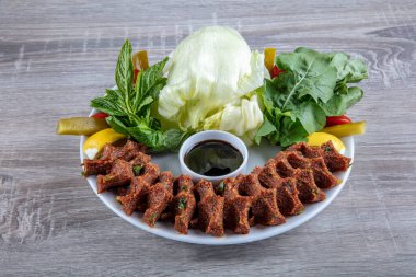 Porselen tabakta limonlu, marullu ve maydanozlu Türk Cig Kofte. 