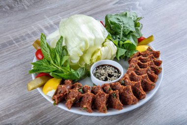 Porselen tabakta limonlu, marullu ve maydanozlu Türk Cig Kofte. 