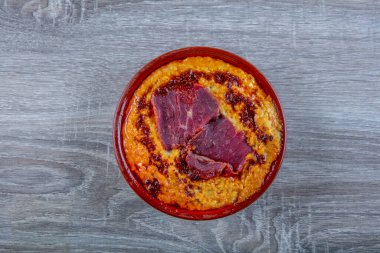 Nohut humusu bir kasede domuz pastırması ve ekmek ile servis edilir..