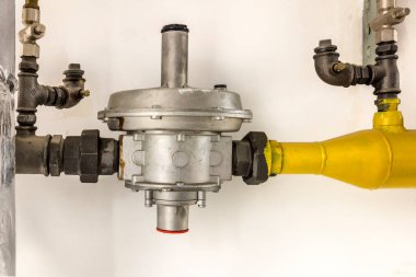 Büyük endüstriyel su arıtma ve kazan dairesi. Parlak çelik borular, kırmızı pompalar ve vanalar..