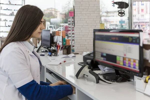 a female pharmacist working on a computer at the pharmacy