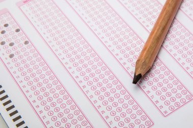 Sınavlara giren öğrencilerin elleri, optik test formunda kalem tutarak sınav kağıtları hazırlıyor ve sınıfta sınav kağıtları hazırlıyor. Eğitim Değerlendirme Kavramı. Yumuşak odak 