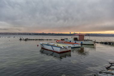 Gün batımında kıyıya demirlemiş balıkçı teknelerinin güzel manzarası.