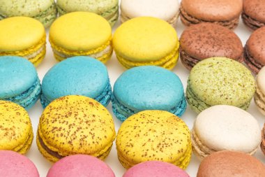 Renkli Fransız badem kurabiyeleri arka planı, yakın plan. Farklı renkte badem kurabiyeleri. Lezzetli tatlı makaron, fırın konsepti..