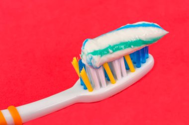 Kırmızı arkaplanda diş fırçası ve diş macunu