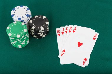 Yeşil arkaplanda poker çipleri ve kartlar