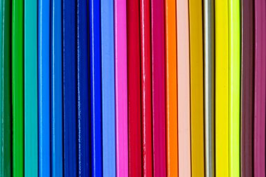 Üst üste beyaz bir arka plan üzerinde renkli kalemler