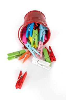 colorful wooden clothespins in bucket on white background