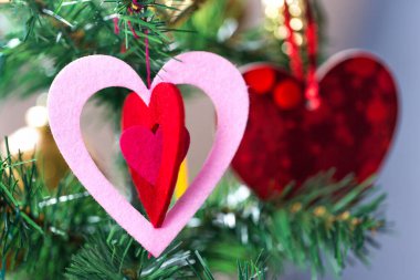 Ahşap zemin üzerinde kırmızı kalpler olan Noel ağacı.