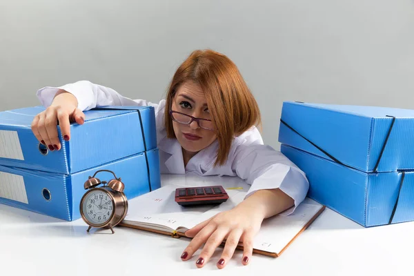 beautiful young girl with a calculator. hard worker working at the table in the office.