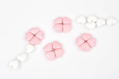 Beyaz arkaplanda pembe kalp şeklinde kurabiyeler