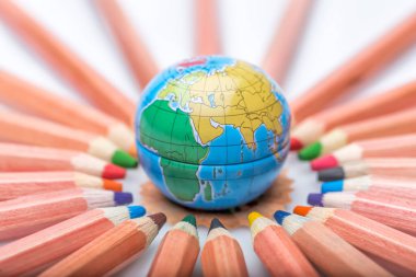 Küre ve renkli kalemler, beyaz üzerine izole edilmiş. 