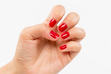 Beyaz arka planda tırnak kırmızısı manikürlü el.