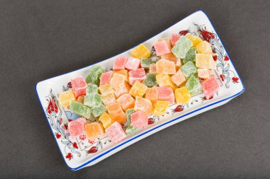 Siyah arka planda bir kasede renkli jöle şekerlemeleri