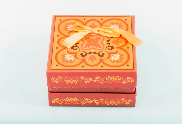 gift box with red bow and gold ribbon on white background