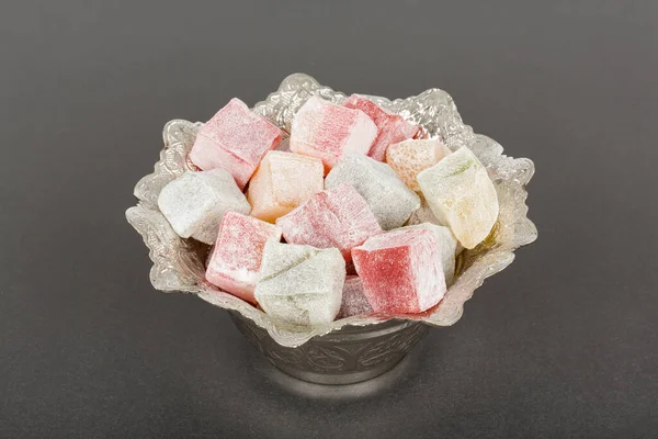 Stock image colorful Turkish Delight in a Turkish metal bowl on a dark background. 