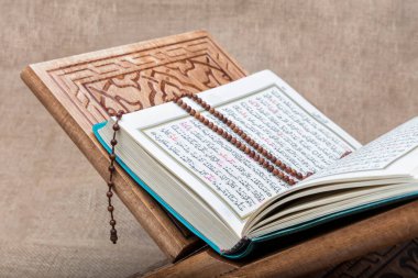 Istanbul, Turkey - December 03, 2016; Holy Quran and prayer beads on the stand with carving ornament.