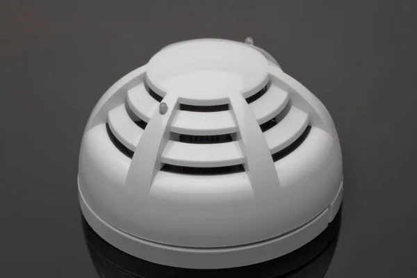 Smoke detector of fire alarm in action, reflection on a black background, fire alarm.