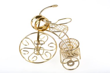 decorative golden bicycle with ribbon on white background