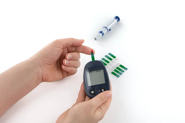 Close-up Of Woman Hands Testing High Blood Sugar With Glucometer. Glucometer and syringe for insulin, monitoring of diabetes mellitus isolated on white background.