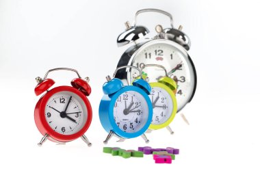 alarm clock and colorful clocks on white background