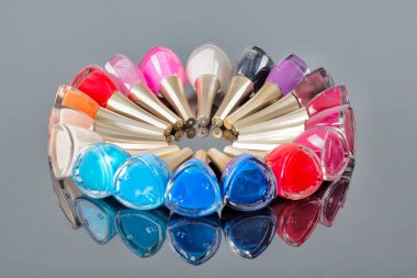 Güzel parlak renklerden oluşan tırnak cilası çeşitleri. Tırnak sanatı ve manikür konsepti. Renkli cilalı ya da ojeli. Yansıması olan siyah bir arkaplanda izole edilmiş.