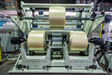 Koli bandı imalatı. Strapping Machine for Industrail Ambalaj Hattı, Fabrika, Endüstri ve Teknoloji konseptinde ambalaj hattı için modern makine.