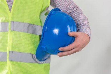 Mühendislik yönetimi inşaatı, mühendis güvenlik miğferi, işçi güvenliği için çalışma alanı arka planında. Busine konsepti. Gri arkaplanda kopyalama alanı olan miğfer tutan inşaat işçisi