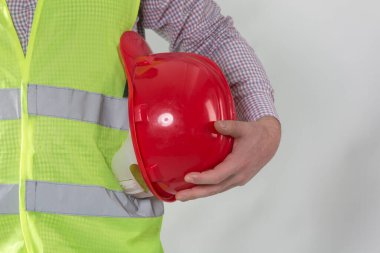 Mühendislik yönetimi inşaatı, mühendis güvenlik miğferi, işçi güvenliği için çalışma alanı arka planında. Busine konsepti. Gri arkaplanda kopyalama alanı olan miğfer tutan inşaat işçisi