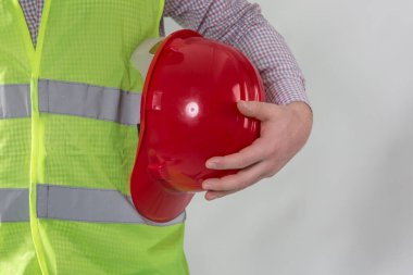 Mühendislik yönetimi inşaatı, mühendis güvenlik miğferi, işçi güvenliği için çalışma alanı arka planında. Busine konsepti. Gri arkaplanda kopyalama alanı olan miğfer tutan inşaat işçisi