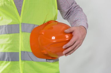 Mühendislik yönetimi inşaatı, mühendis güvenlik miğferi, işçi güvenliği için çalışma alanı arka planında. Busine konsepti. Gri arkaplanda kopyalama alanı olan miğfer tutan inşaat işçisi