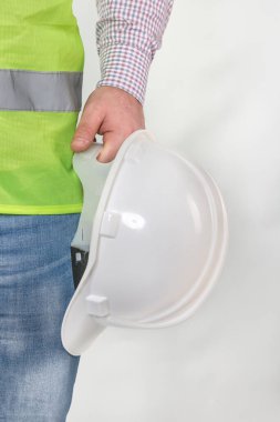 Mühendislik yönetimi inşaatı, mühendis güvenlik miğferi, işçi güvenliği için çalışma alanı arka planında. Busine konsepti. Gri arkaplanda kopyalama alanı olan miğfer tutan inşaat işçisi